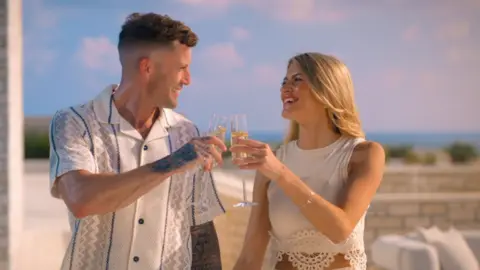 Netflix Billy and Ashleigh smiling at each other with a drink in hand 