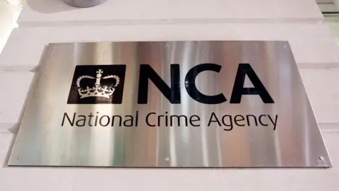 PA Media Photograph of a metallic sign outside the National Crime Agency headquarters in central London.