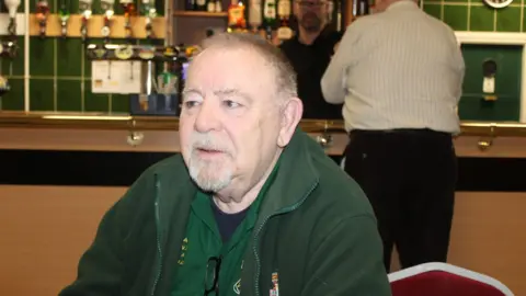 Family handout A portrait shot of Ray Bowen, who has received SABR treatment, sitting in a pub. He has a white beard and grey hair and is wearing a green fleece top and staring to the left of the picture.