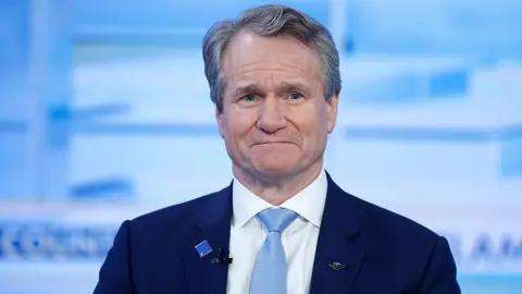 Getty Images Brian Moynihan wearing a navy suit with a white shirt and light blue tie. He has dark grey hair.