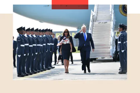 Mandel Ngan/AFP via Getty Images US President Donald Trump (R) and US First Lady Melania Trump (L) walk on the tarmac after disembarking Air Force One 
