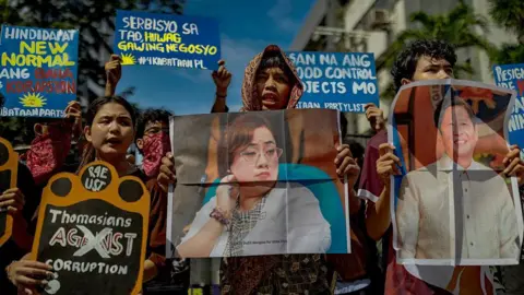 Getty Images Protesters carry banners and photos of Philippine President Ferdinand Marcos and construction magnate Sara Discaya