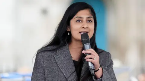 PA Media Zarah Sutlana speaks into a microphone at a protest in London earlier this month.