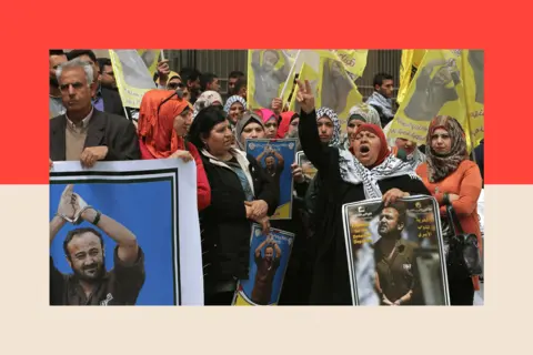 AFP via Getty Images Palestinian protesters wave flags and placards bearing portraits of Fatah leader Marwan Barghuti
