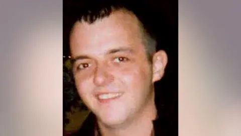 Police Scotland Head shot of Michael Lyons, who is wearing a jacket with a black collar. He is smiling and looking at the camera. He has short black hair, combed forward.