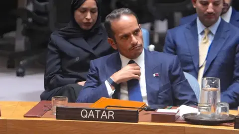 Getty Images Qatari Prime Minister Sheikh Mohammed bin Abdulrahman al-Thani sits at a UN Security Council meeting wearing a blue jacket and tie.