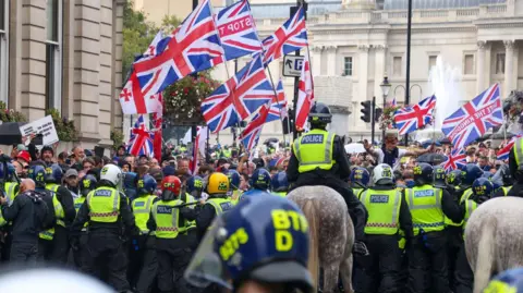 EPA Protesters taking part in a 'Unite the Kingdom' rally are held back by police officers, some on horses, in central London.