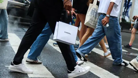 Bloomberg/Getty A shopper carries a Chanel store bag in New York, US, on Saturday, Sept. 6, 2025.