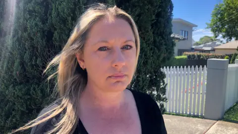 Melanie Grimmer Melanie Grimmer standing in front of a tree in her neighbourhood