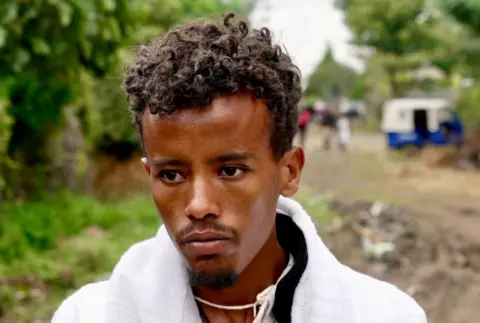 Amensisa Negera / BBC  Fikre Tilahun, with a white top, stares