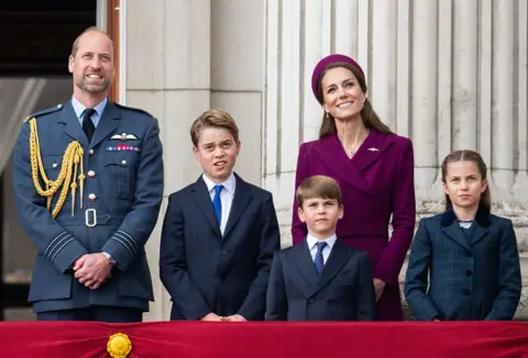 Getty Images Prince William, Prince George, Catherine, Princess of Wales, Prince Louis and Princess Charlotte watching the flypast for the 80th anniversary of VE Day in May - they are all in formal dress on a balcony outside