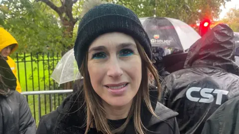 Anna Bergson poses for the camera - she is wearing a dark bobble hat in the rain at the vigil on Friday.