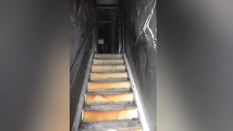 Electrical Safety First The stairs of the Chilworth home of Emma Wills after a fired caused by a modified e-bike. The stairs are ripped up and either side of the stair well is black. 