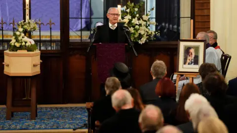 PA Media Man speaking at a person's funeral
