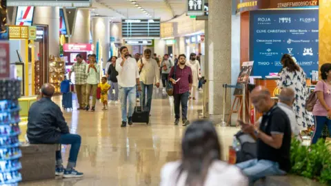 Getty Images Passengers in the departure area of Chhatrapati Shivaji Maharaj International Airport, operated by Adani Group, in Mumbai, India, on Wednesday, May 22, 2024.