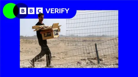 BBC A file photo showing a man carrying a box with aid