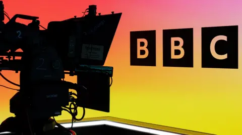 BBC A camera operator in a BBC studio, showing the BBC logo against a multi-coloured backdrop
