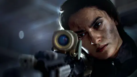 EA Screenshot from Battlefield 6 shows a female sniper resting her cheek on the stock of a long-range rifle as she looks down its scope. There is a look of concentration on her face, which is flecked with black dust.