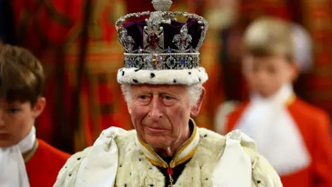 Getty Images King Charles wears a bejewelled crown and a large fur robe.