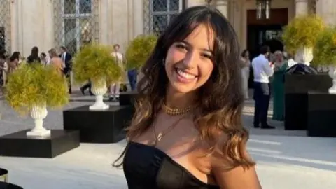 Supplied Girl smiling for the camera with long brown hair.