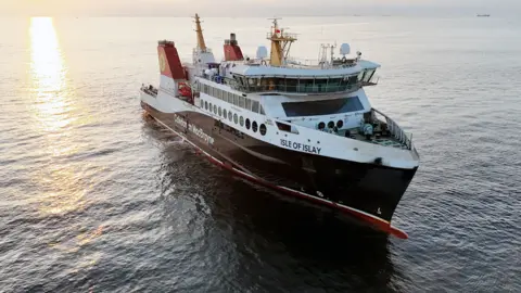 CMAL A black and white ferry with red funnels and Isle of Islay written on the bow