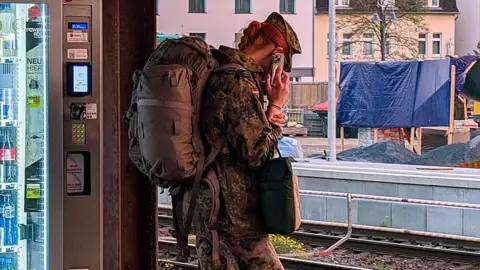 NurPhoto via Getty Images A female Bundeswehr soldier stands at Fulda train station in Hesse, Germany, on October 12, 2025