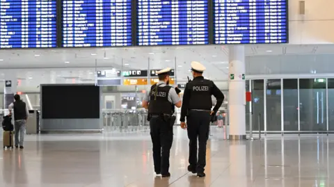 Reuters Police officers walk at the airport in Munich, after both runways at Munich airport were closed on Friday evening
