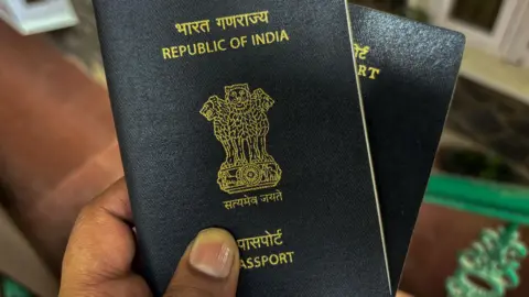 Getty Images Photo of a person holding blue coloured Indian passport