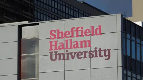 Sign saying Sheffield Hallam University on a modern steel and concrete building