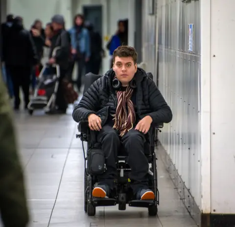 Alex moving towards the exit at Finsbury Park underground station