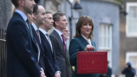 BBC Rachel Reeves with a red box, stood next to treasury ministers in Downing Street.