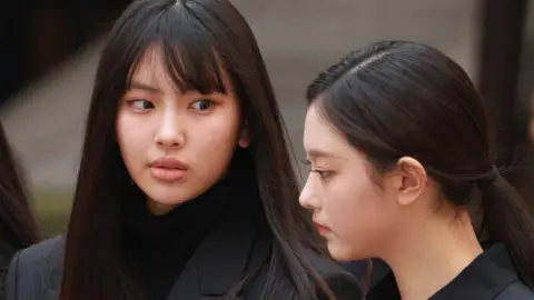 Getty Images Close-up of Hyein and Haerin dressed in black, with long black hair