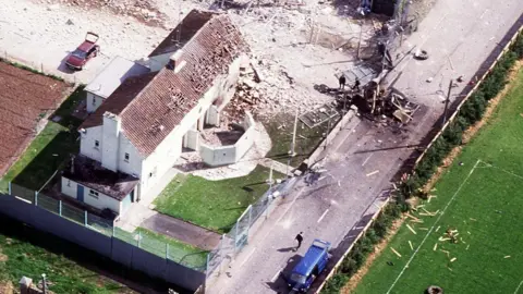 Pacemaker Aerial view of Loughgall police station shows part of the perimeter fence and the building destroyed by the IRA bomb while the blue van in which most of the IRA members were killed is visible and the bottom of the picture
