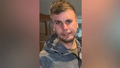 PSNI HANDOUT Jordan Webb pictured with short light hair and stubble. He is wearing a grey coat and light top. 