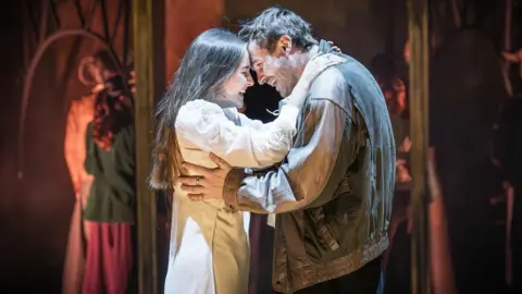 Mark Brenner A smiling woman and man embrace on stage