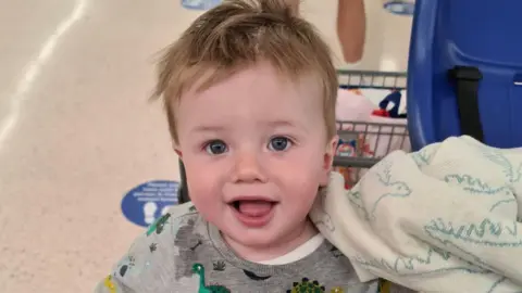 Family handout Oliver Steeper smiling at the camera sat in a supermarket trolley