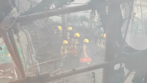 William Li A top shot of several firefighters in heavy gear at the Wang Fuk Court complex in this photo shot by William Li