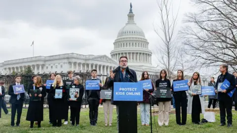 Getty Images  Former Meta engineer Arturo Béjar speaks during a rally from a lectern with a blue sign reading "protect kids online". The US Capitol building can be seen in the background. 
