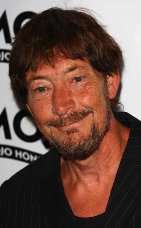 Getty Images Chris Rea in a black jacket and top, smiling