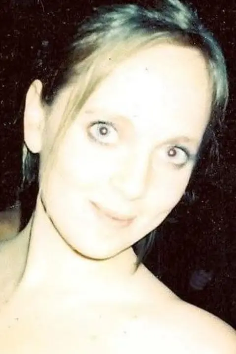 Jenny Evans Jenny Evans smiles at the camera, she is wearing a red top and has her hair up in an up do. 