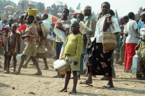 Mirrorpix/Getty Images A group of people going about their days in Rwanda following the civil war