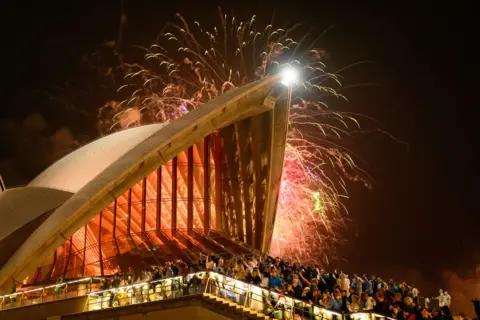 Getty Images People enjoy the New Year's Eve firework displays at Opera House on December 31, 2025 in Sydney, Australia.