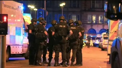 PA Media Armed police officers at the scene of the Manchester Arena attack in May 2017