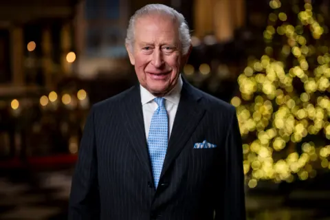 PA Media King Charles III in front of Christmas tree delivering speech in Westminster Abbey