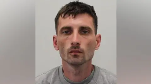 Met Police A man with brown hair and a short beard