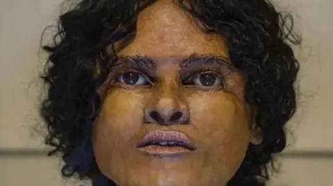 Graham Huntley A woman. She has black curly hair and brown eyes. 