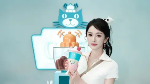 Jellycat Chinese actress Yang Mi, in a white top, holds a matcha latte plushie at the Jellycat pop-up store in Shanghai