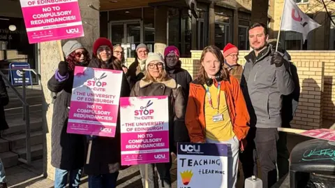 UCU staff holding pink and white banners outside the University of Edinburgh on Monday.