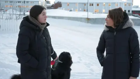 Pilu Chemnitz (left) talks to BBC's Katya Adler while walking her dog in Nuuk, Greenland