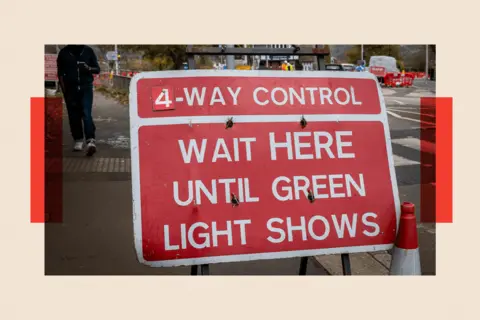 In pictures via Getty Images A sign that reads: "4 way control. Wait here until green light shows."